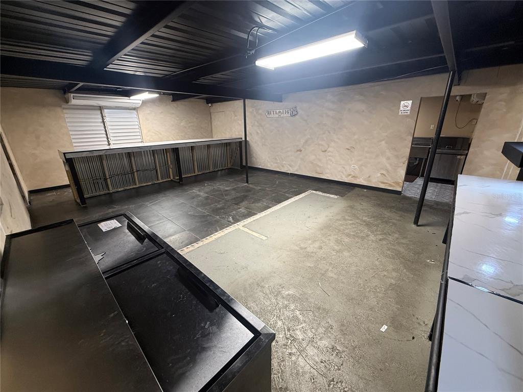 An interior room features a long bar, tile flooring, exposed ceiling beams, and fluorescent lighting — 116 GUANICA, GUANICA, PR
