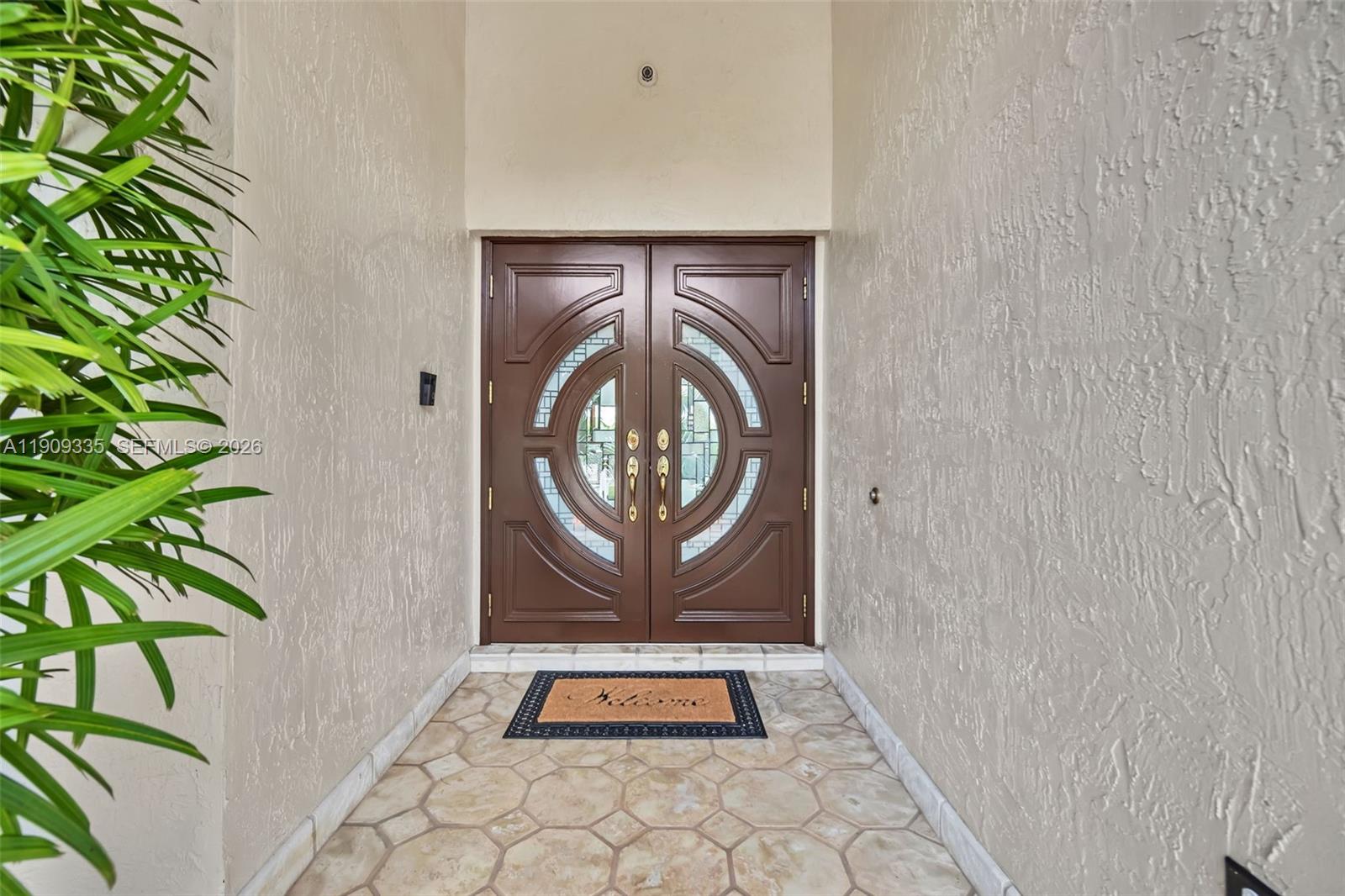 A brown double door with circular glass inserts sits at the end of a tiled entryway — 15462 SW 115th St, Miami FL 33196, MIAMI, FL