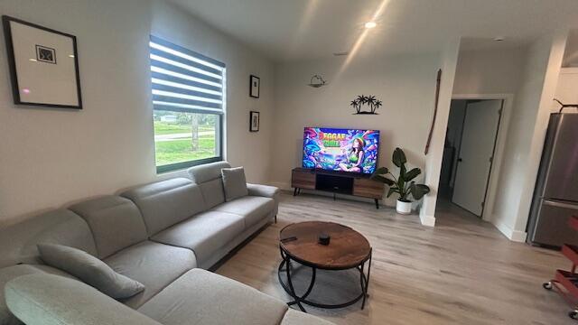 A living room features a light gray sectional sofa, a round coffee table, and a television — 1151 Jabara Circle, FL 33935, FL