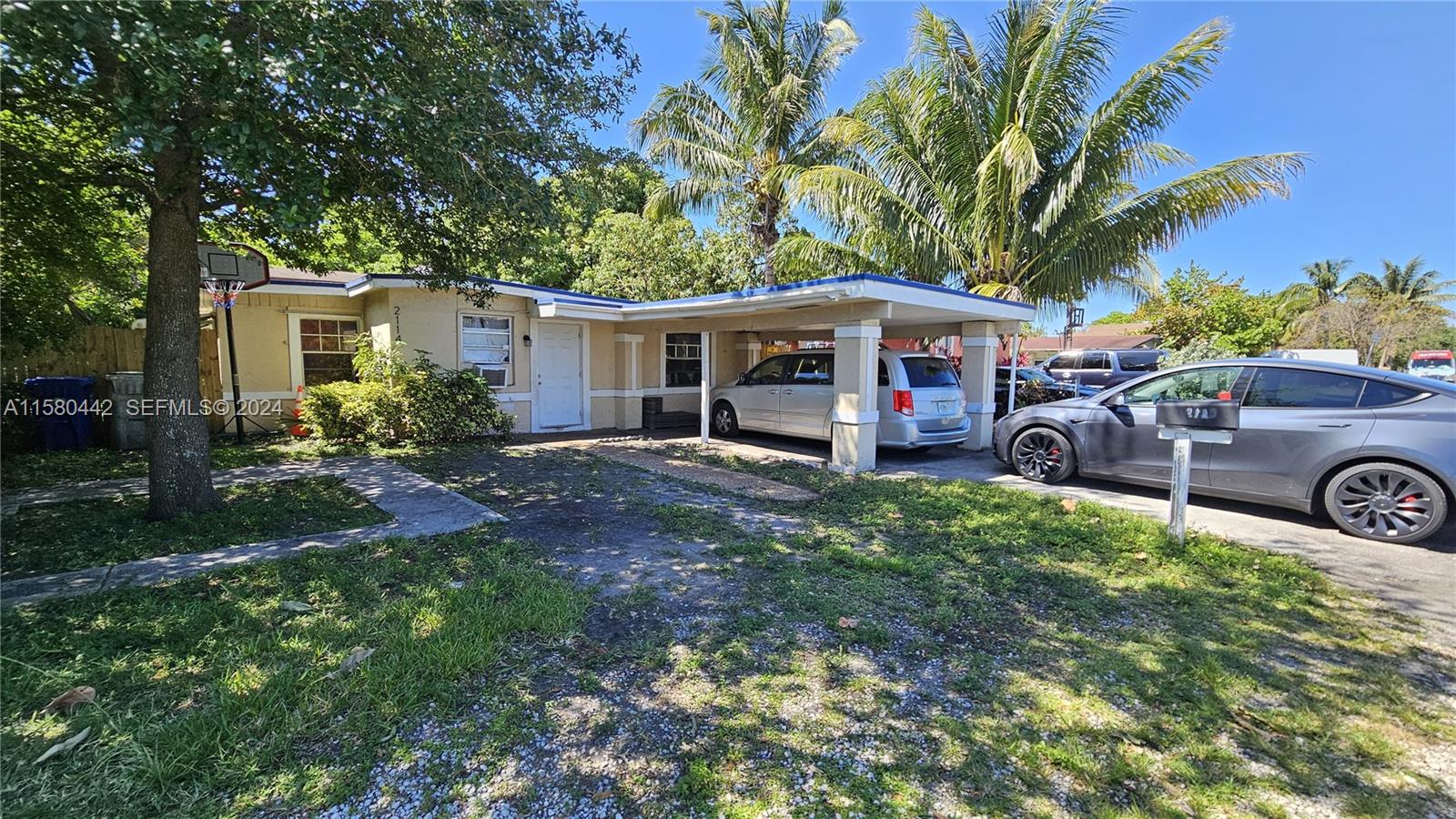 A single-story house with a carport, a driveway, and a front yard with trees — 2114 NW 5th St, Pompano Beach FL 33069, POMPANO BEACH, FL