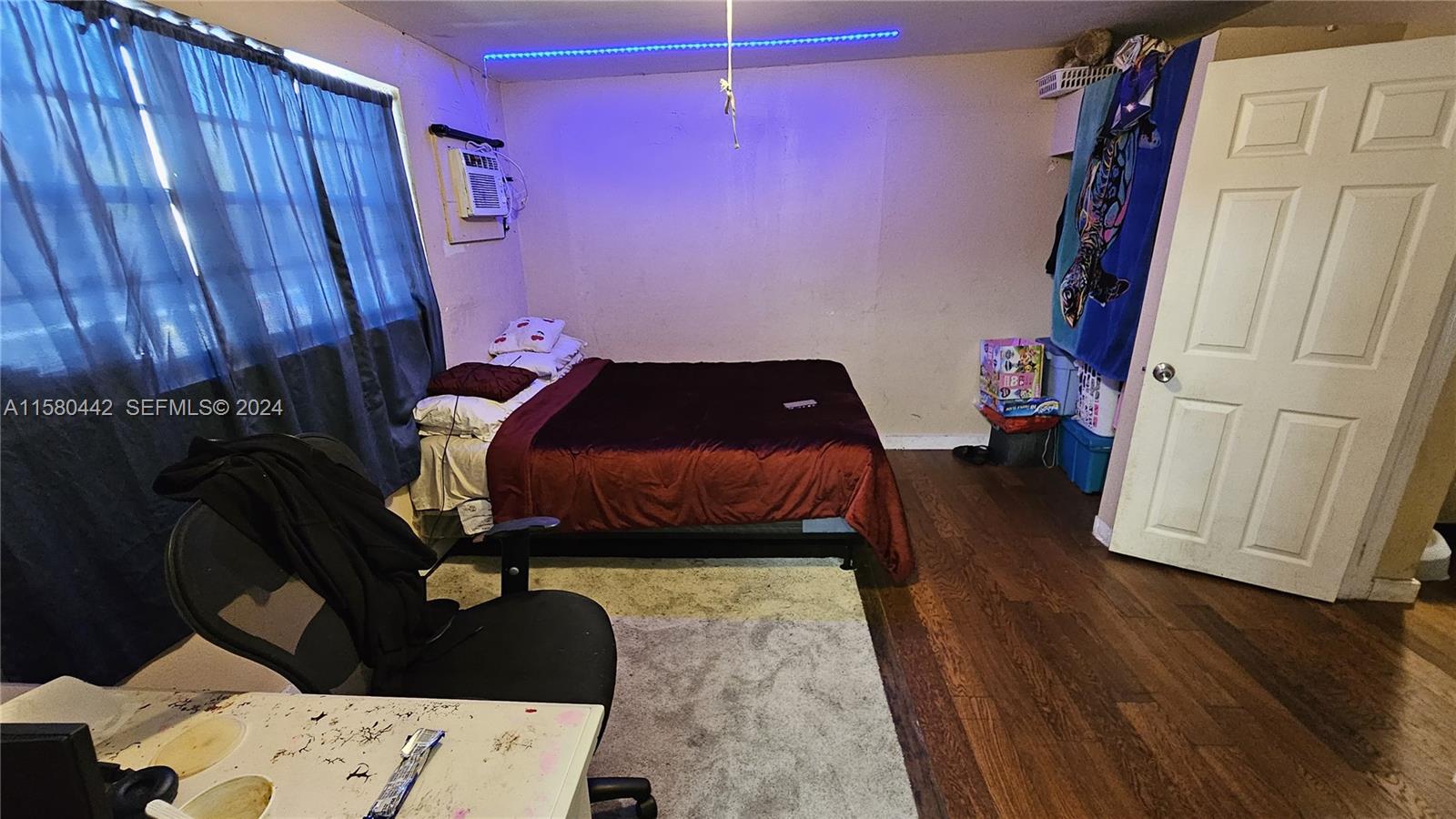 A bedroom features a bed with a maroon comforter, hardwood flooring, and blue LED lighting — 2114 NW 5th St, Pompano Beach FL 33069, POMPANO BEACH, FL