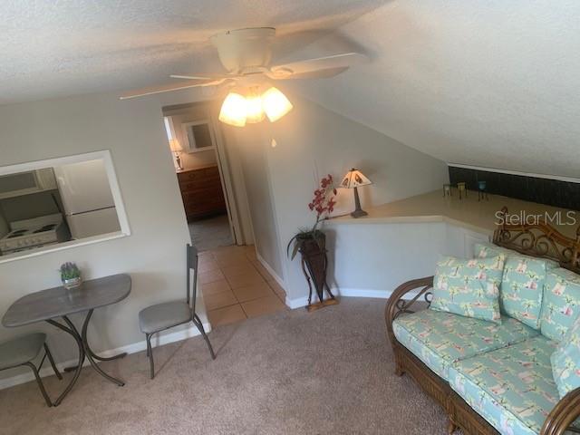 A living area features a ceiling fan, a small dining table, and a wicker sofa — 211 W BAY AVENUE UNIT A, LONGWOOD, FL