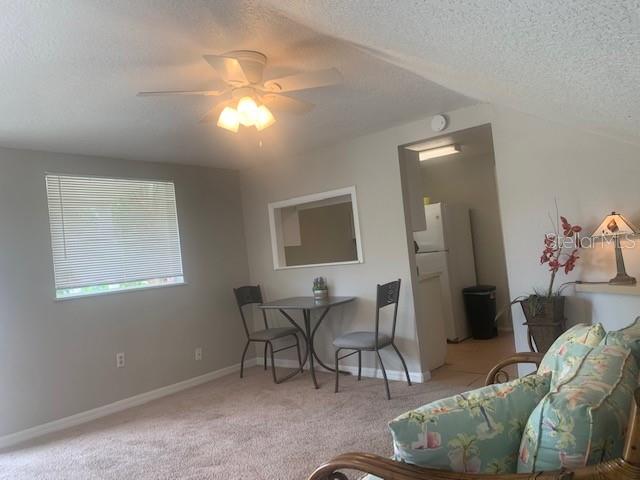 A dining area with a small table and chairs sits adjacent to a kitchen pass-through — 211 W BAY AVENUE UNIT A, LONGWOOD, FL
