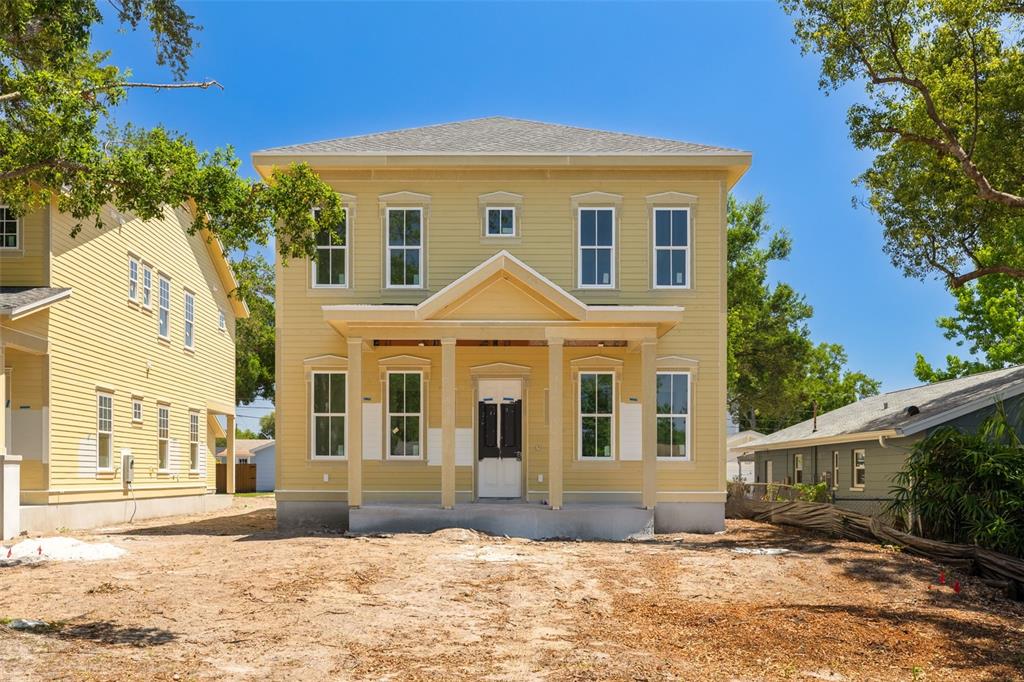 A two-story yellow house with a front porch stands on a dirt lot — 5326 7TH AVENUE N, ST PETERSBURG, FL