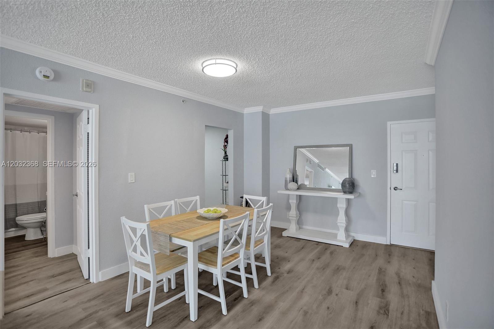 A dining area features a wooden table with white chairs, a console table, and flooring — 2501 S Ocean Dr # 302, Hollywood FL 33019, HOLLYWOOD, FL