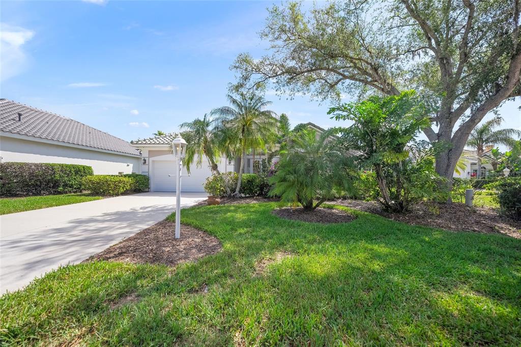 An open-concept kitchen and living area features a large chandelier, tile floors, and wood cabinetry — 6923 LENNOX PLACE, UNIVERSITY PARK, FL