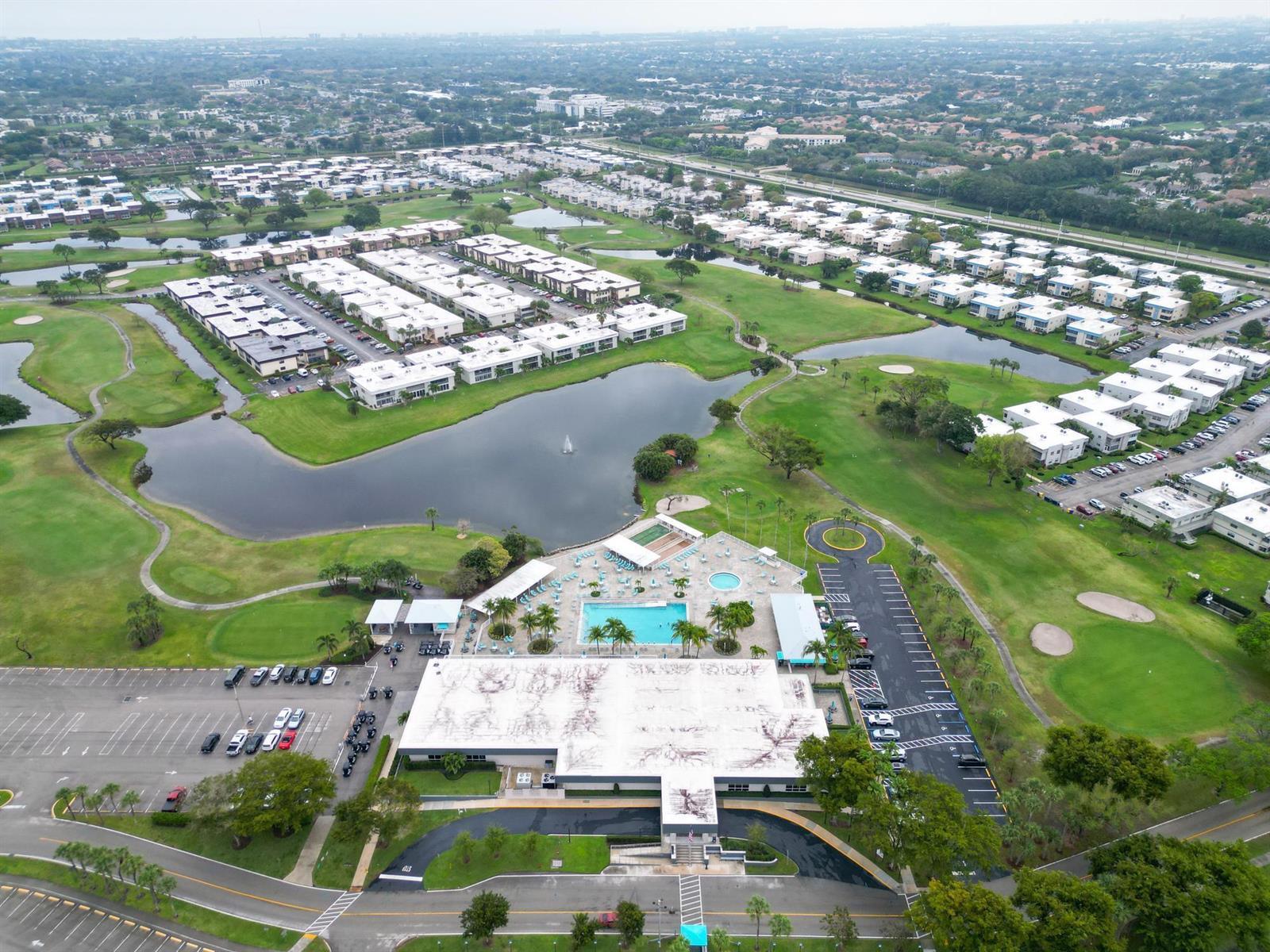 An aerial view shows a community clubhouse with a pool, parking lots, and surrounding golf course — 362 Burgundy H, Delray Beach FL 33484, DELRAY BEACH, FL