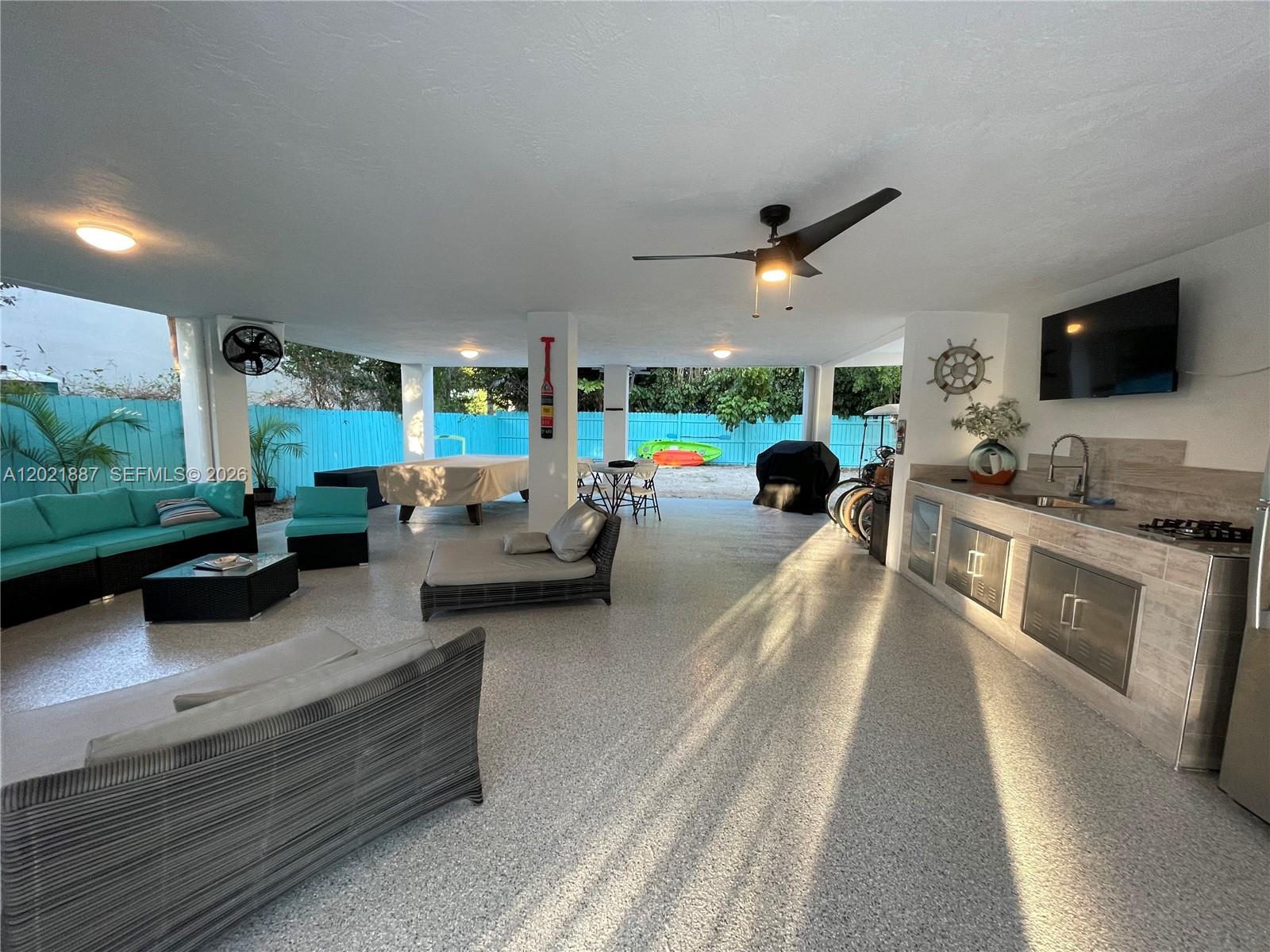 An outdoor covered patio features a kitchen area, lounge seating, and a pool table — 414 Coconut Dr, Key Largo FL 33037, KEY LARGO, FL