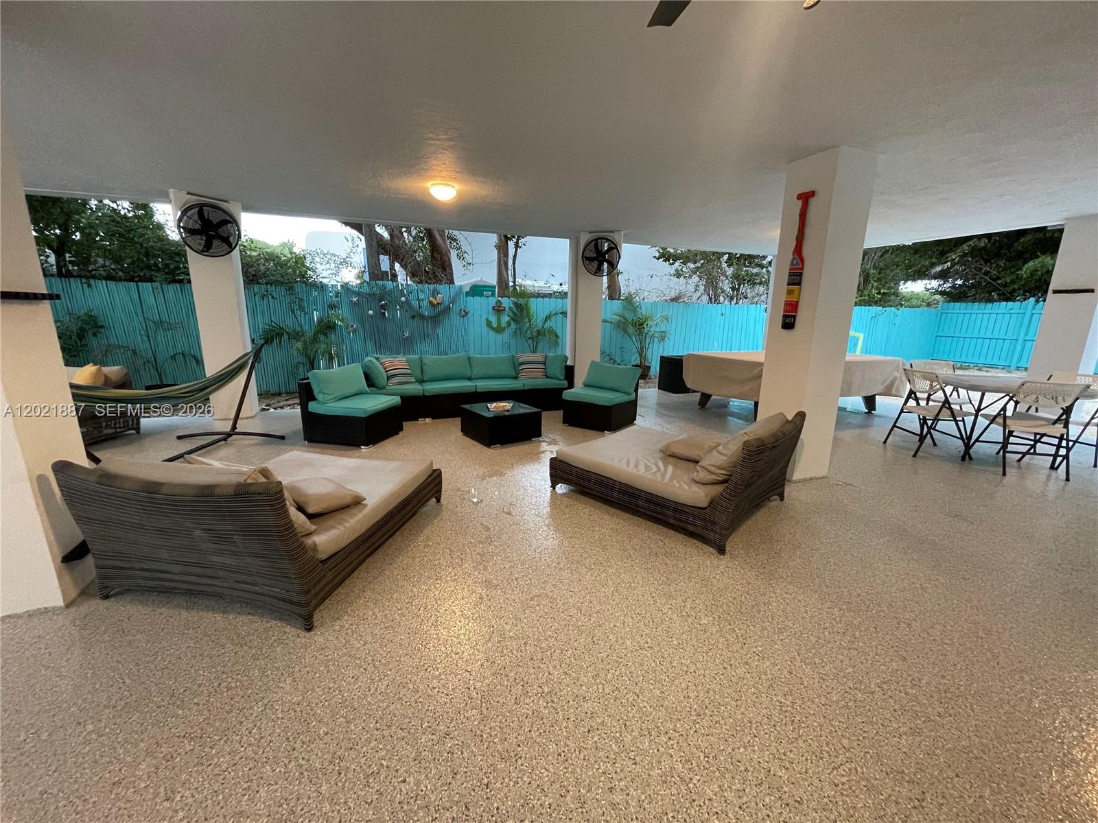 A covered outdoor patio features a seating area, lounge chairs, and a dining table — 414 Coconut Dr, Key Largo FL 33037, KEY LARGO, FL