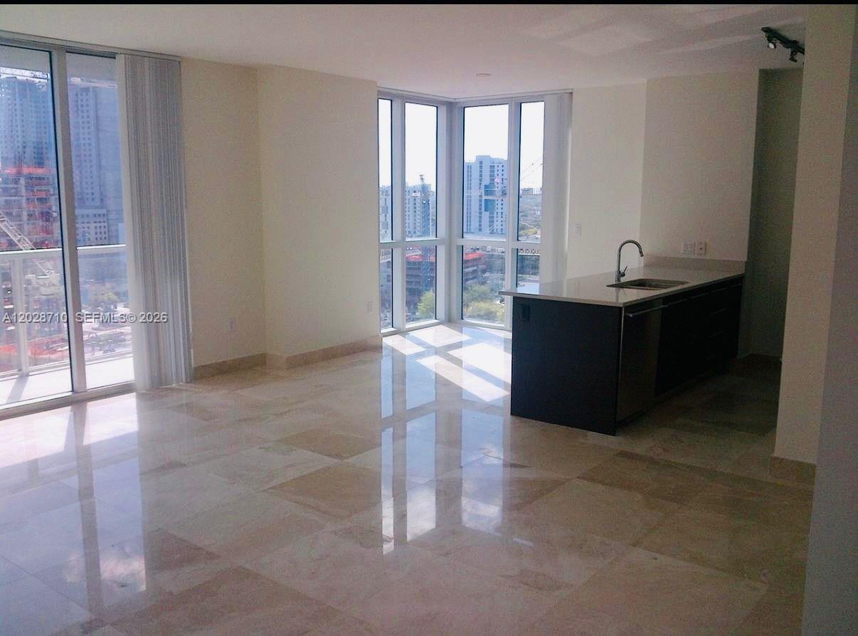 An open-concept living area features marble floors, a kitchen island, and floor-to-ceiling windows — 55 SE 6th St # 1502, Miami FL 33131, MIAMI, FL