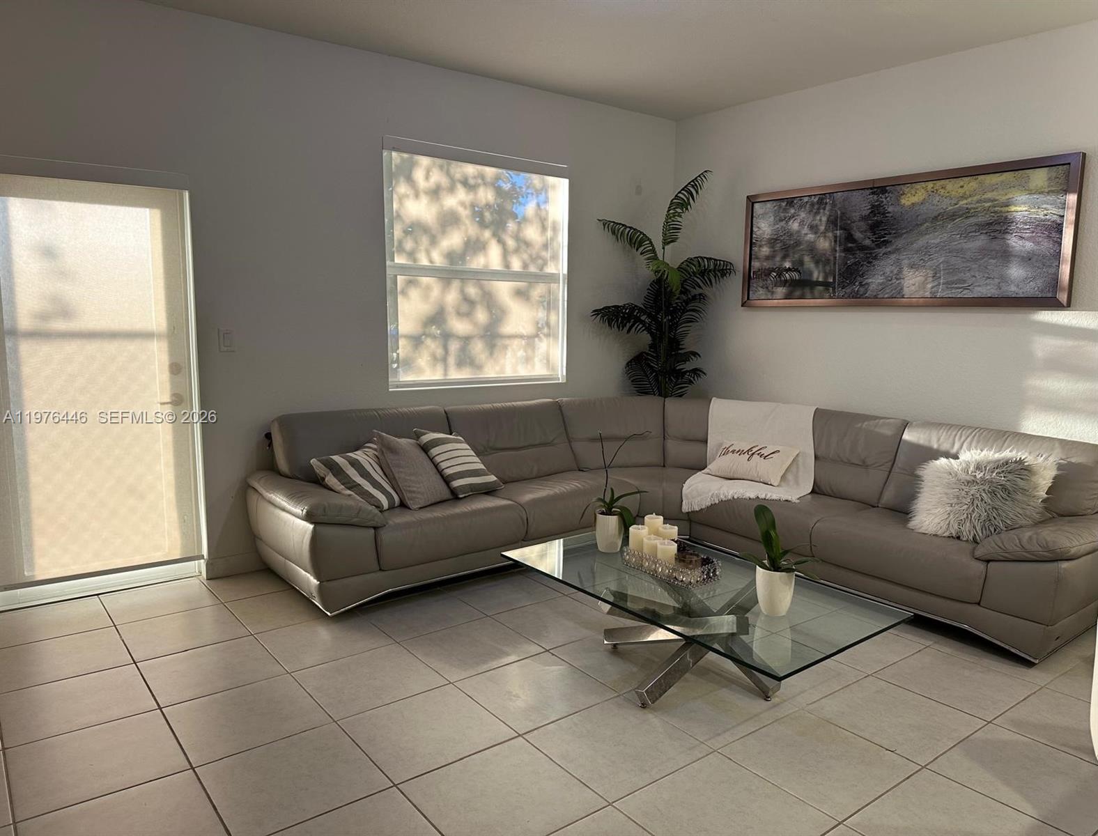 A living room features a grey sectional sofa, a glass coffee table, and tile flooring — 18576 SW 136th Ct, Miami FL 33177, MIAMI, FL