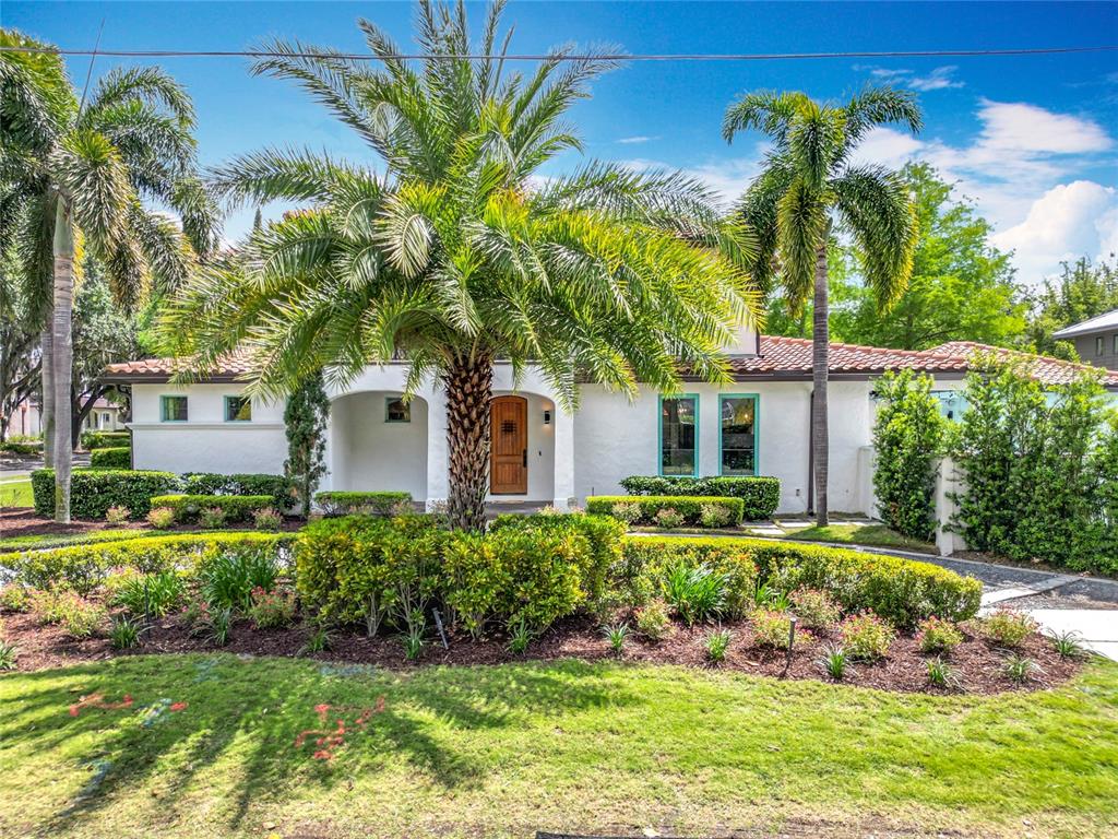 A white single-story house with a tile roof, palm trees, and landscaped front yard — 2614 PARKLAND DRIVE, WINTER PARK, FL