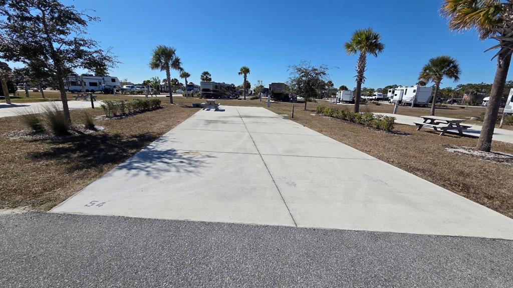 A paved RV campsite pad features a picnic table under a clear blue sky — 54 TIKI TURN E, LAKE WALES, FL