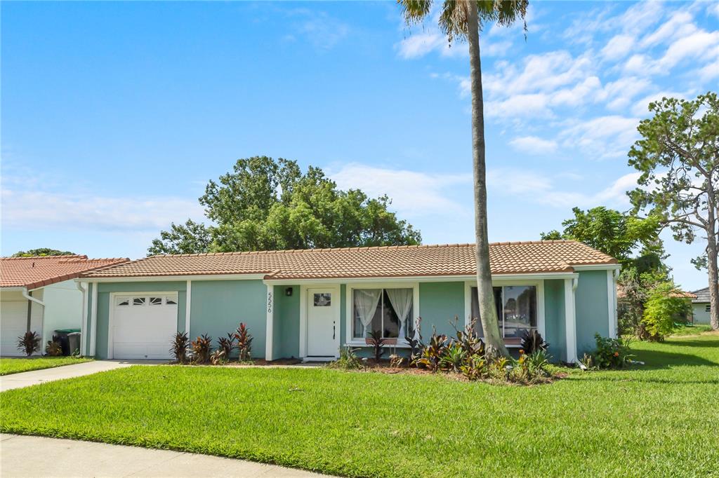 A single-story house with a light green exterior, a tiled roof, and a front lawn — 5556 MEMORIAL DRIVE, ORLANDO, FL