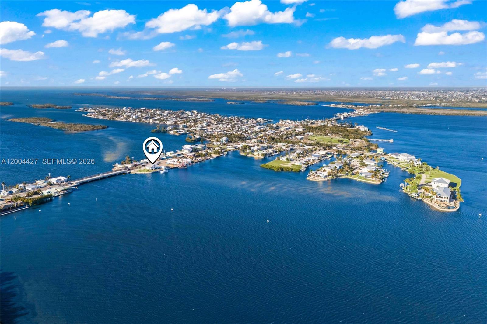 This aerial view shows a coastal community surrounded by water with a bridge connection — 4767 Pine Island RD NW, Matlacha FL 33993, MATLACHA, FL