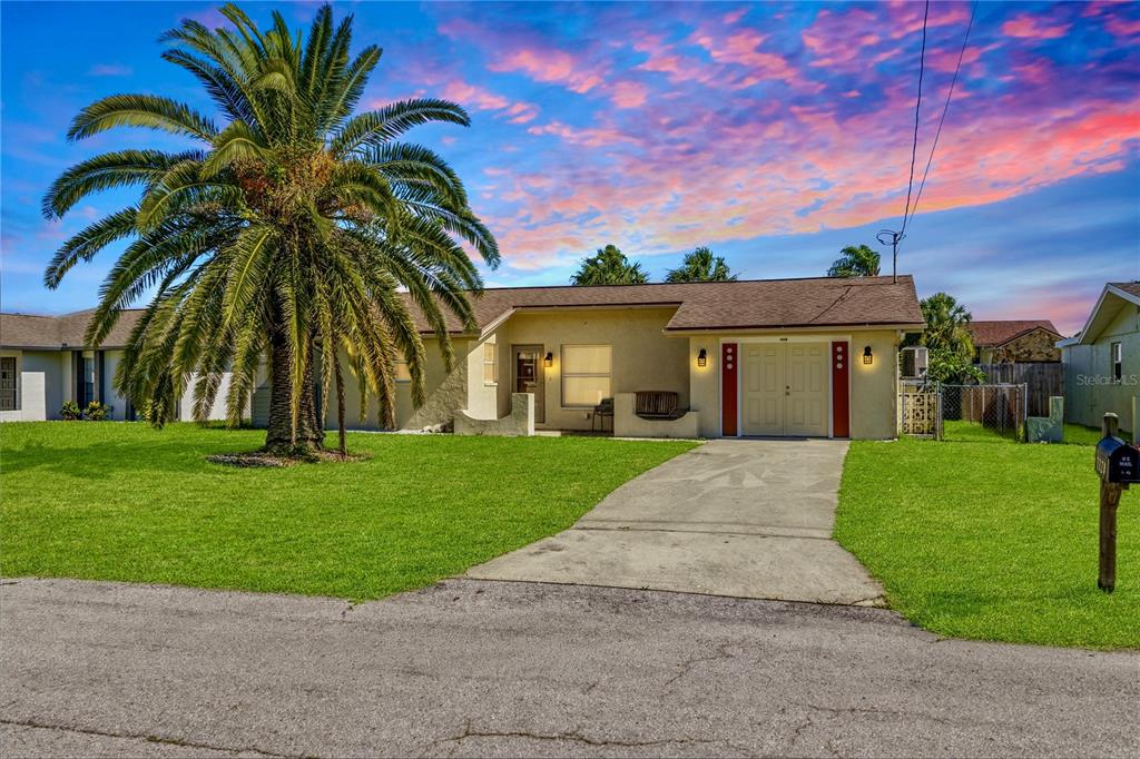 A single-story house with a palm tree, a concrete driveway, and a garage — 7328 MAKO DRIVE, HUDSON, FL