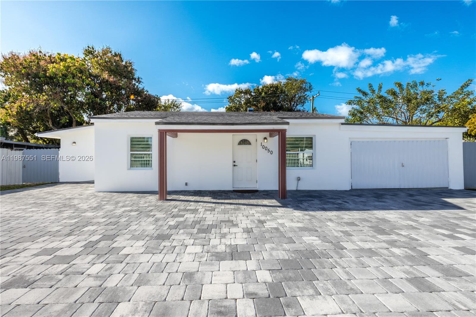 A single-story white house with a paved driveway and a covered front entryway — 10050 SW 171st St # 10050, Miami FL 33157, MIAMI, FL