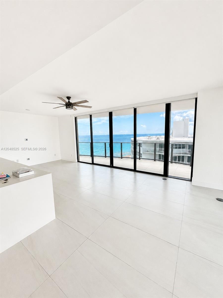 A bright, minimalist living area features large floor-to-ceiling windows with an ocean view — 730 N Ocean Blvd # 1205, Pompano Beach FL 33062, POMPANO BEACH, FL