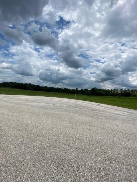 A paved cul-de-sac overlooks a grassy field under a cloudy sky — 5698 QUICKSILVER, FLORAL CITY, FL