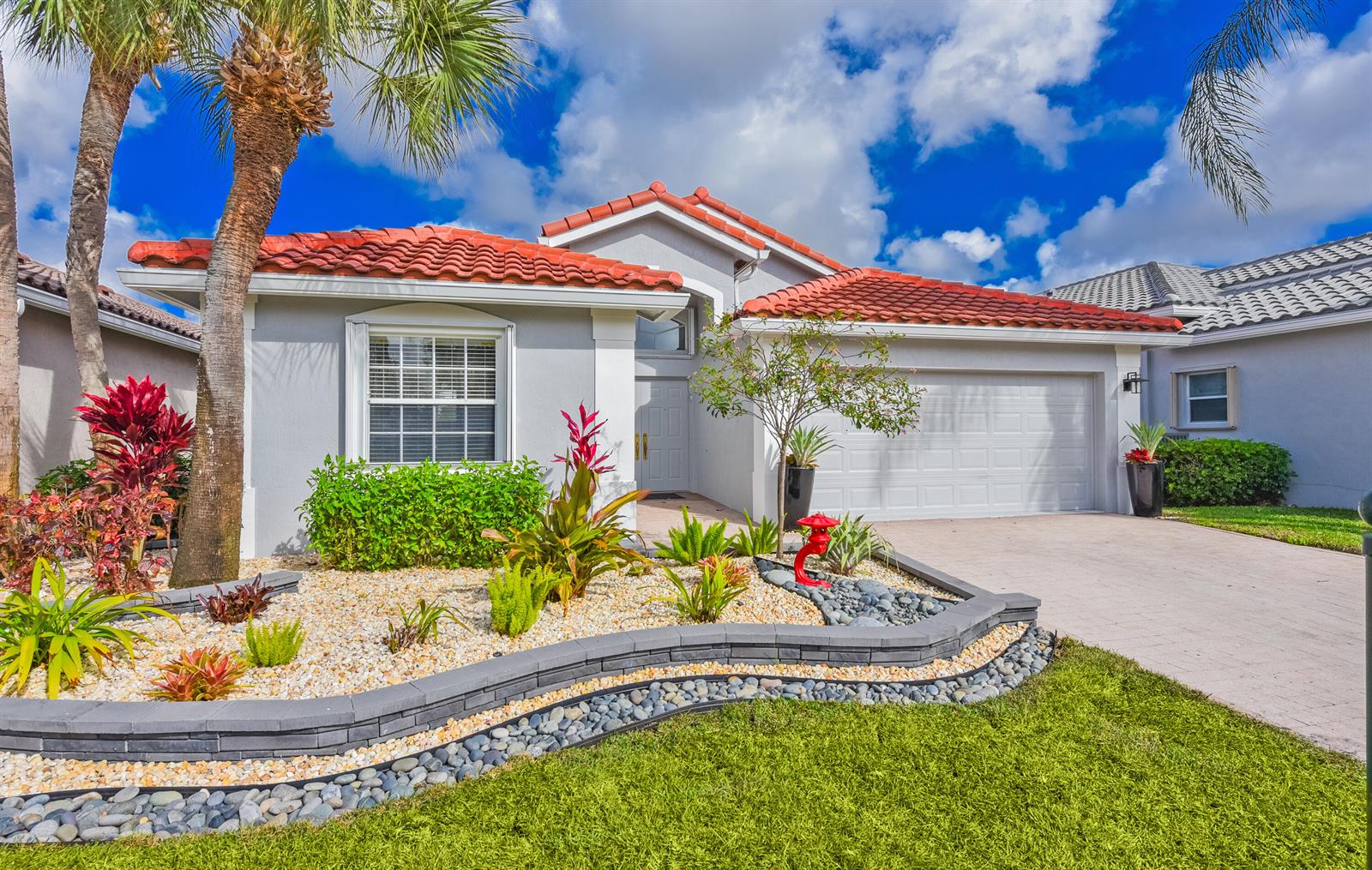 A single-story house with a red tile roof, gray stucco walls, and a landscaped front yard — 7118 Treviso Lane, Boynton Beach FL 33472, BOYNTON BEACH, FL