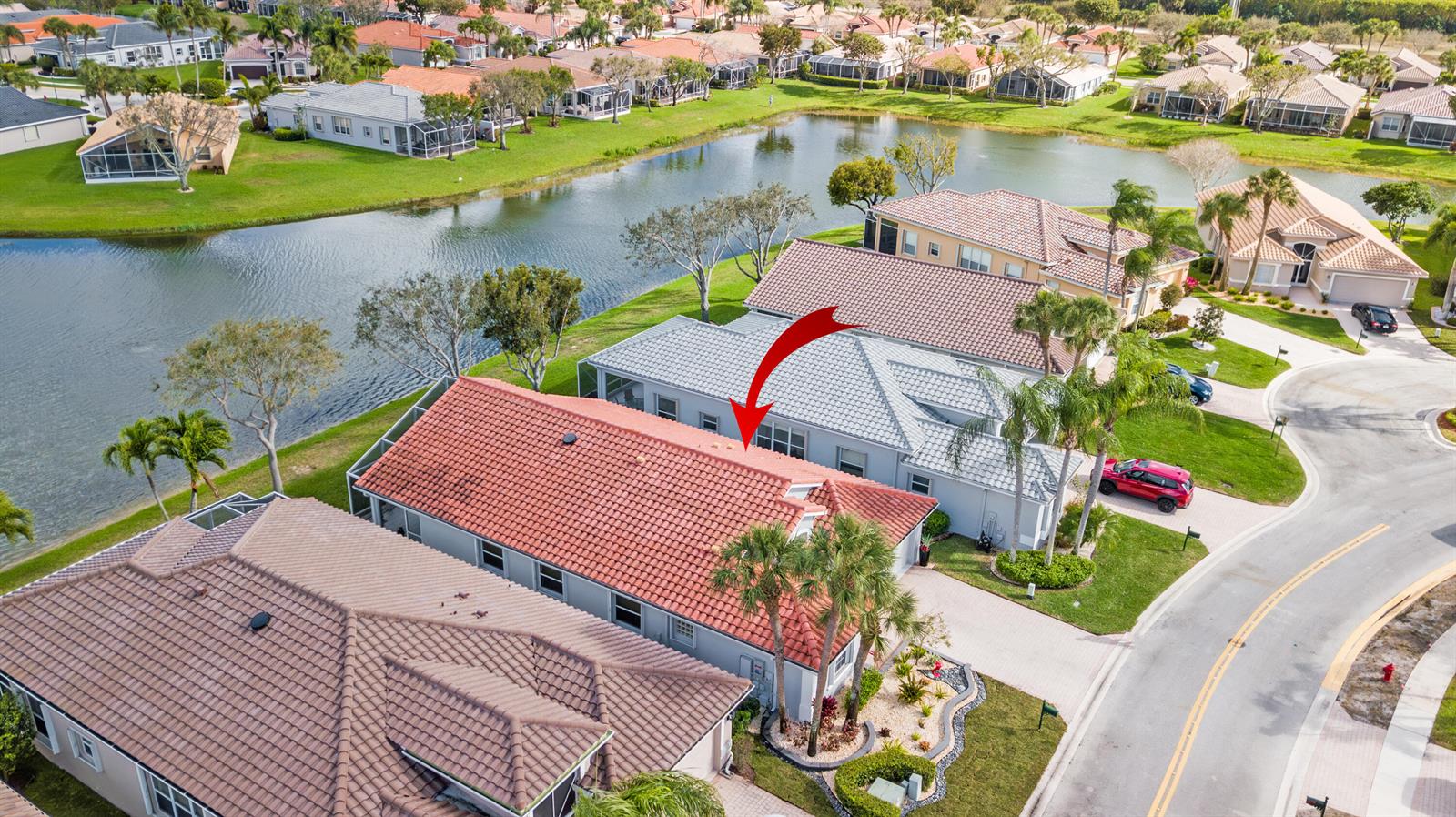 An aerial view shows a residential neighborhood with houses featuring tiled roofs and pools — 7118 Treviso Lane, Boynton Beach FL 33472, BOYNTON BEACH, FL