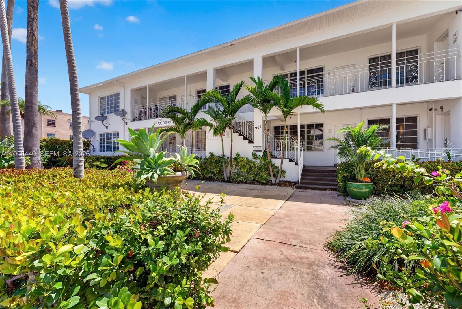 A two-story white apartment building features exterior walkways, palm trees, and a landscaped front yard — 901 Pennsylvania Ave, Miami Beach FL 33139, MIAMI BEACH, FL