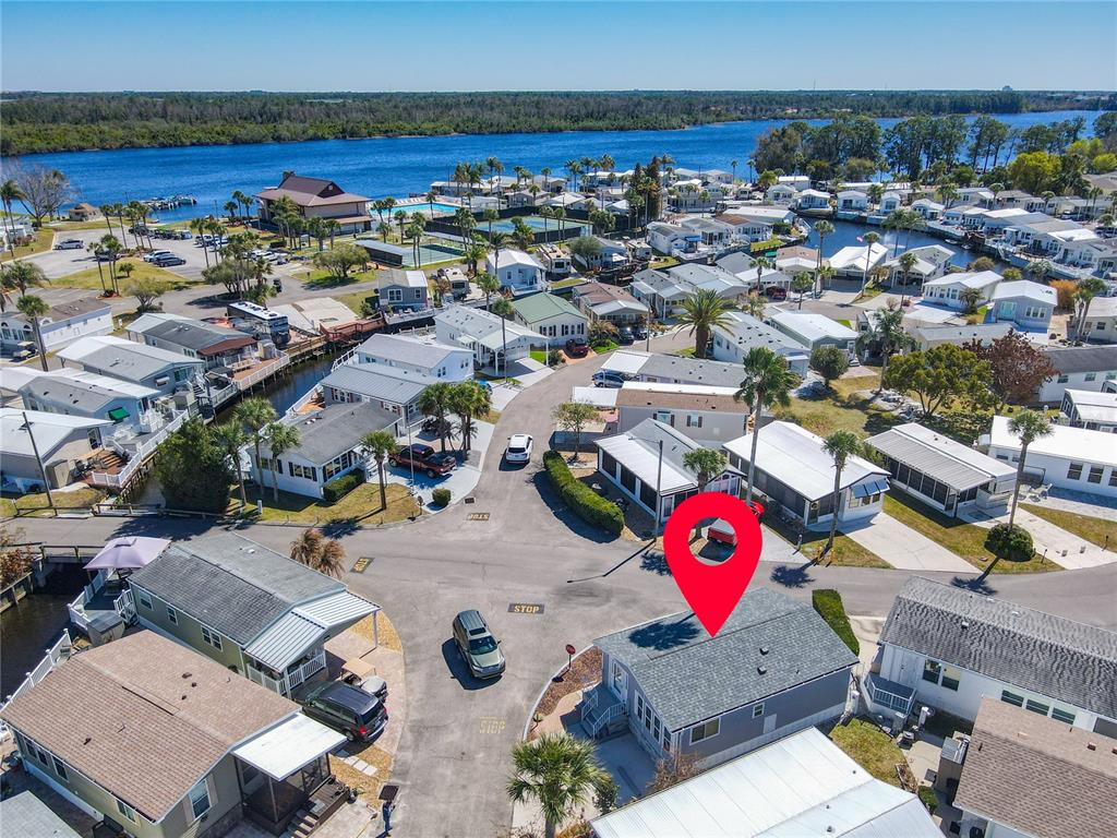 An aerial view shows a residential neighborhood of manufactured homes situated near a large lake — 9000 US HWY 192 UNIT 311, CLERMONT, FL