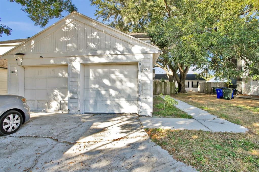 A white detached two-car garage with a concrete driveway and a sidewalk leading to the back — 1817 CRYSTAL GROVE DRIVE, LAKELAND, FL