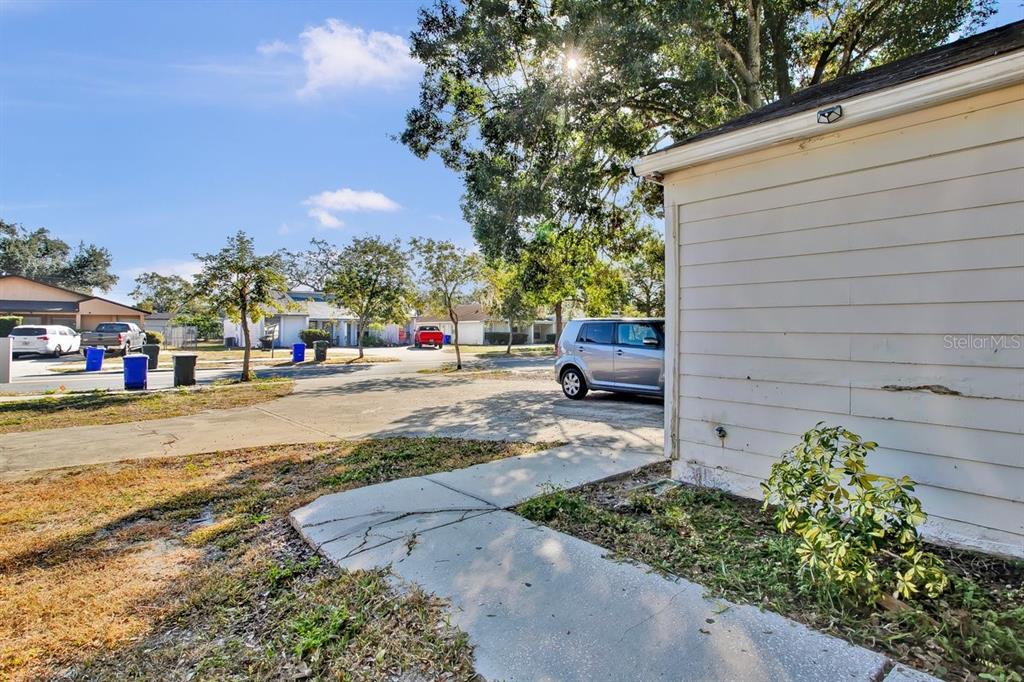 A view of a concrete driveway and walkway beside the side wall of a house — 1817 CRYSTAL GROVE DRIVE, LAKELAND, FL