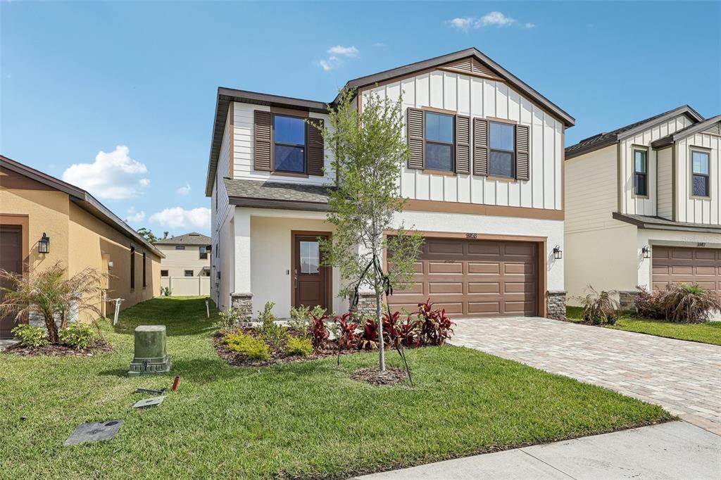 A two-story suburban house with white vertical siding, a brown garage door, and a driveway — 3153 CUP DRIVE, LAKELAND, FL