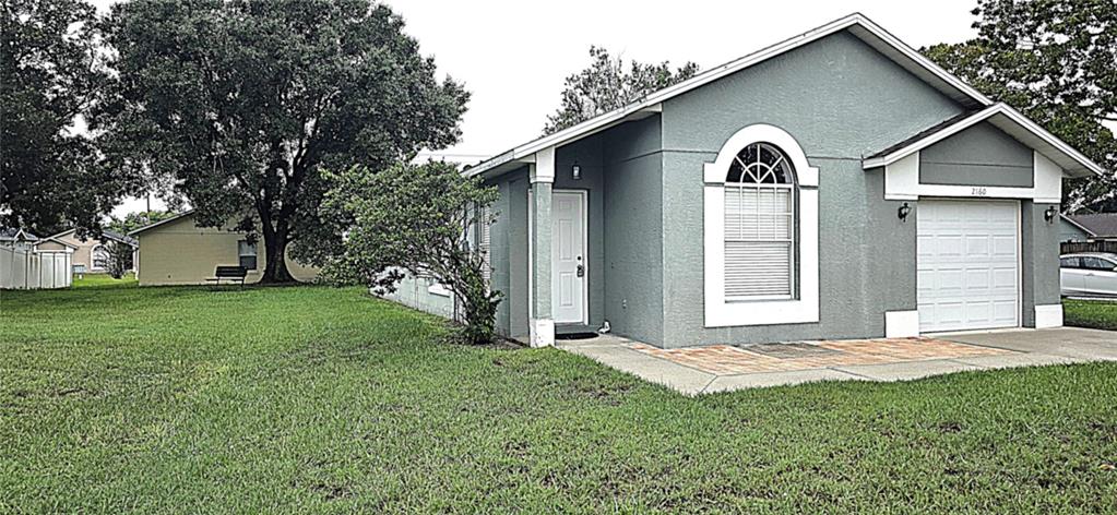 A gray single-story house with a white front door, arched window, and attached garage — 2160 EOLA COURT, OVIEDO, FL