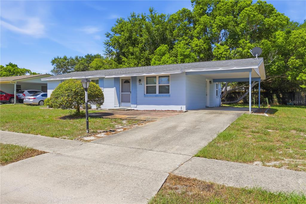 A light blue single-story house with a carport and a concrete driveway — 2456 KIMBERLY DRIVE, DELTONA, FL