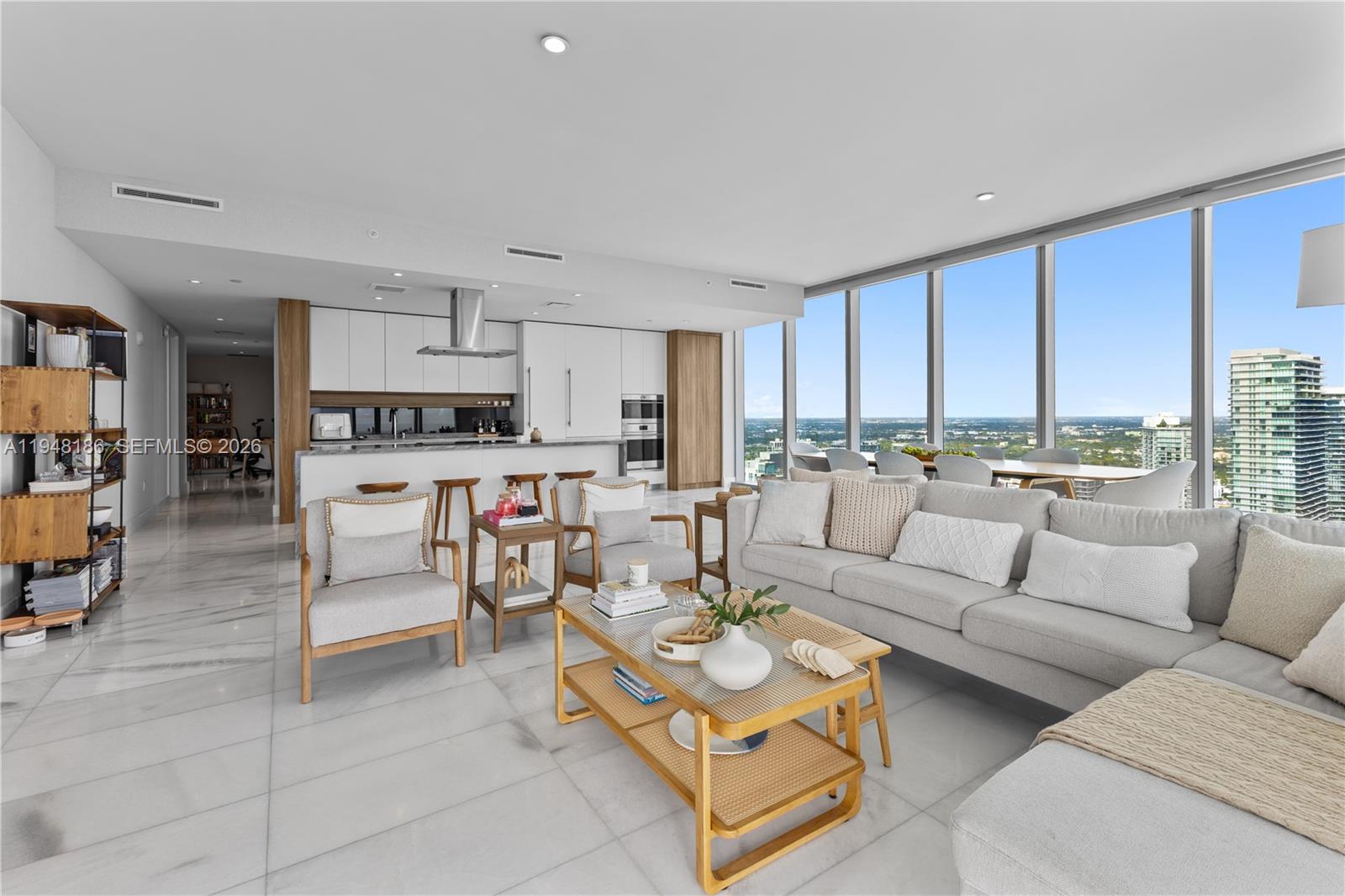 A modern open-concept living room and kitchen feature floor-to-ceiling windows and marble flooring — 700 NE 26th Ter # 4701, Miami FL 33137, MIAMI, FL