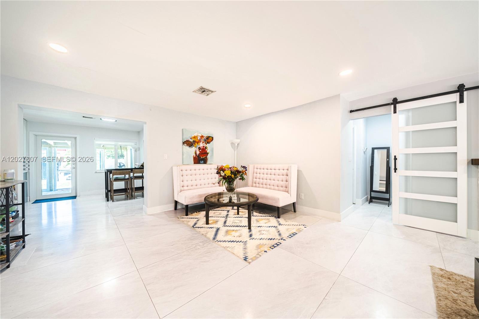 A living area features two pink tufted benches, a glass coffee table, and tile flooring — 1101 NE 5th St, Hallandale Beach FL 33009, HALLANDALE BEACH, FL