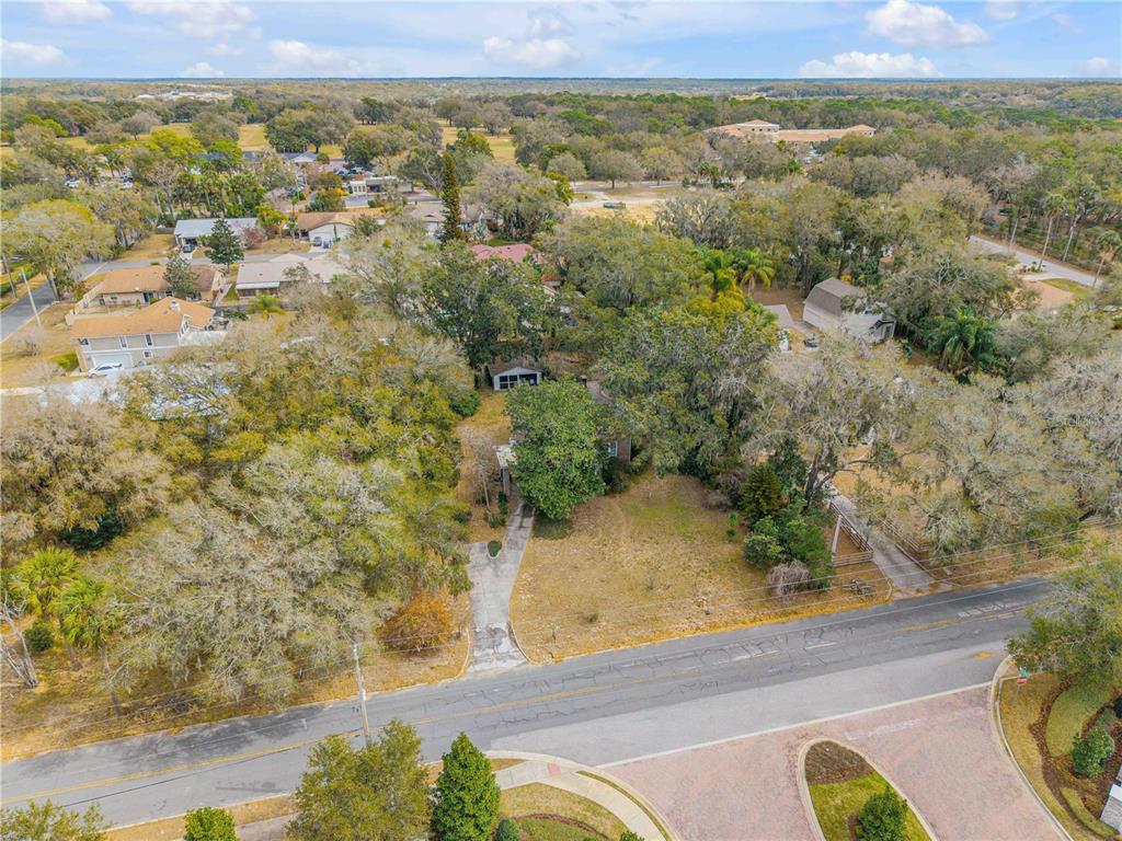 An aerial view shows a house with a driveway surrounded by trees and residential streets — 0 S CLAYTON STREET, MOUNT DORA, FL