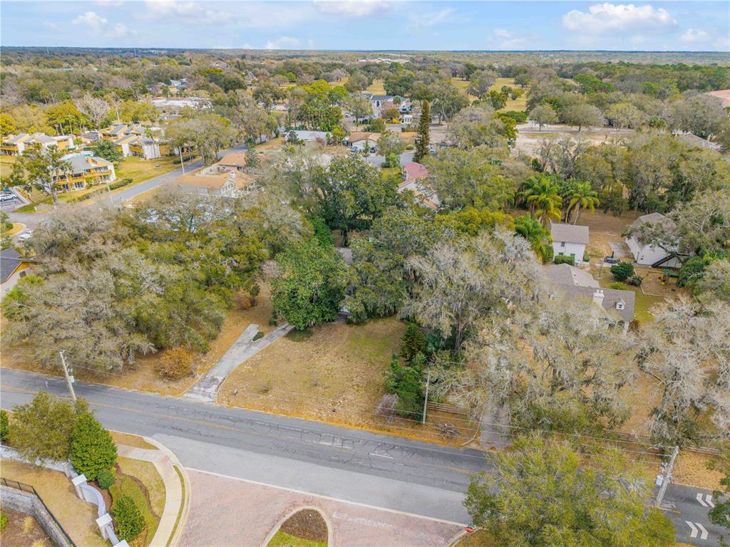 An aerial view shows a residential lot with mature trees and a driveway — 0 S CLAYTON STREET, MOUNT DORA, FL