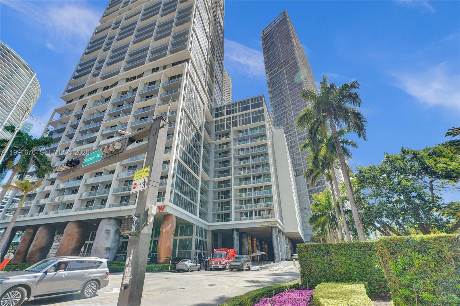 A low-angle exterior view shows the Icon Brickell towers with distinctive moai-style support columns — 475 Brickell Ave # 5010, Miami FL 33131, MIAMI, FL