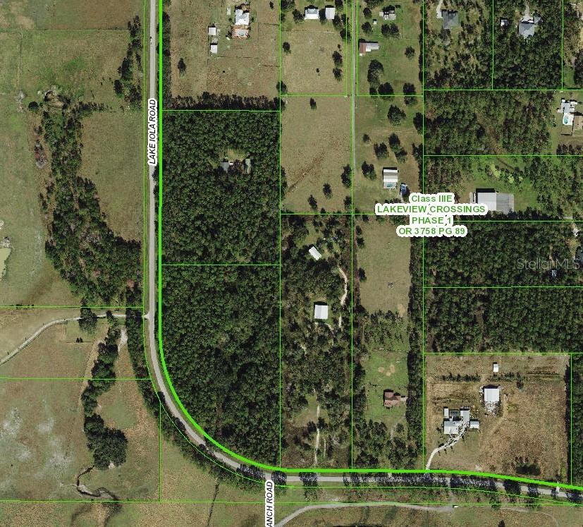 This aerial map shows a rural area with roads, wooded lots, and residential properties — TBD LAKE IOLA ROAD, DADE CITY, FL