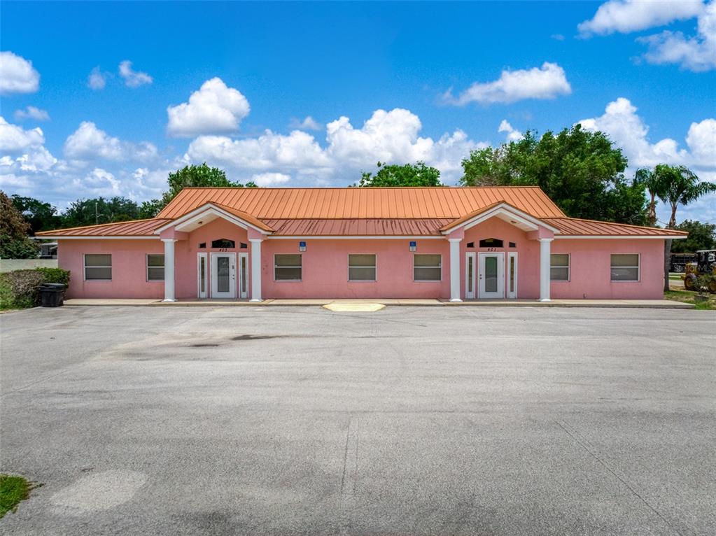 A pink, single-story commercial building with a metal roof and two symmetrical entrances — 401 W INTERLAKE BOULEVARD, LAKE PLACID, FL