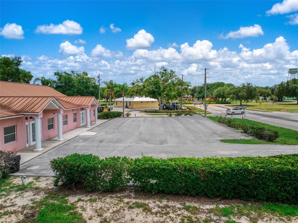 An exterior view of a pink building with a metal roof and an adjacent parking lot — 401 W INTERLAKE BOULEVARD, LAKE PLACID, FL