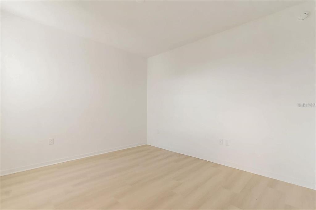 An empty room with white walls and light-colored wood-look flooring — 5587 MILLENIA PARK BLVD UNIT 515, ORLANDO, FL