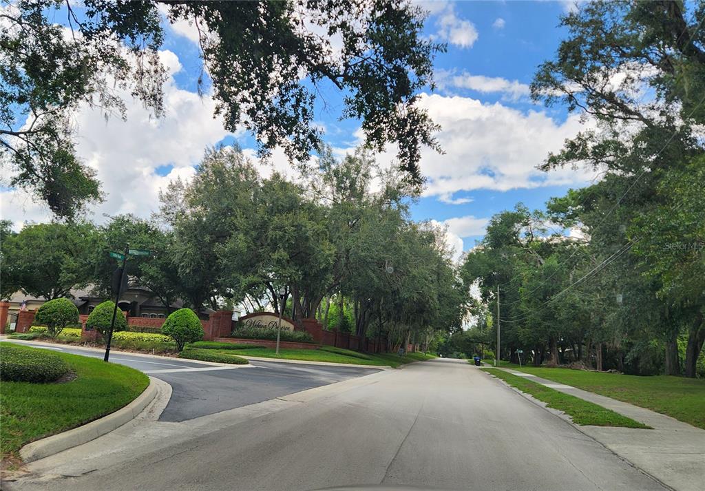 A paved road leads to the brick entrance sign of the Wekiva Preserve neighborhood — 1048 USTLER ROAD, APOPKA, FL