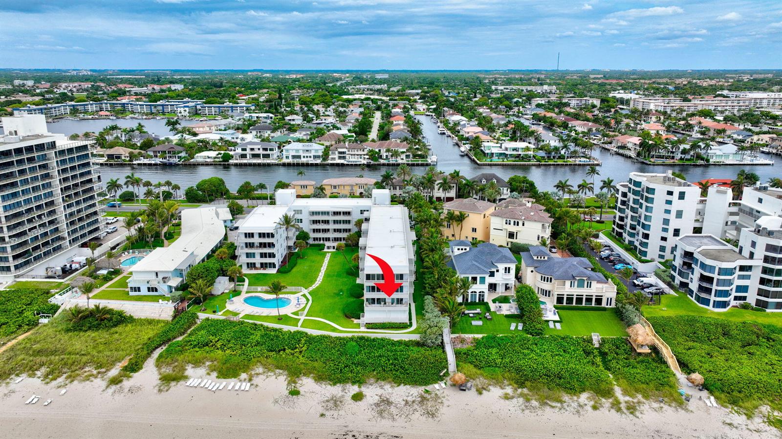 An aerial view shows a beachfront condominium complex with a red arrow pointing toward a balcony — 2701 S Ocean Boulevard # 21, Highland Beach FL 33487, HIGHLAND BEACH, FL