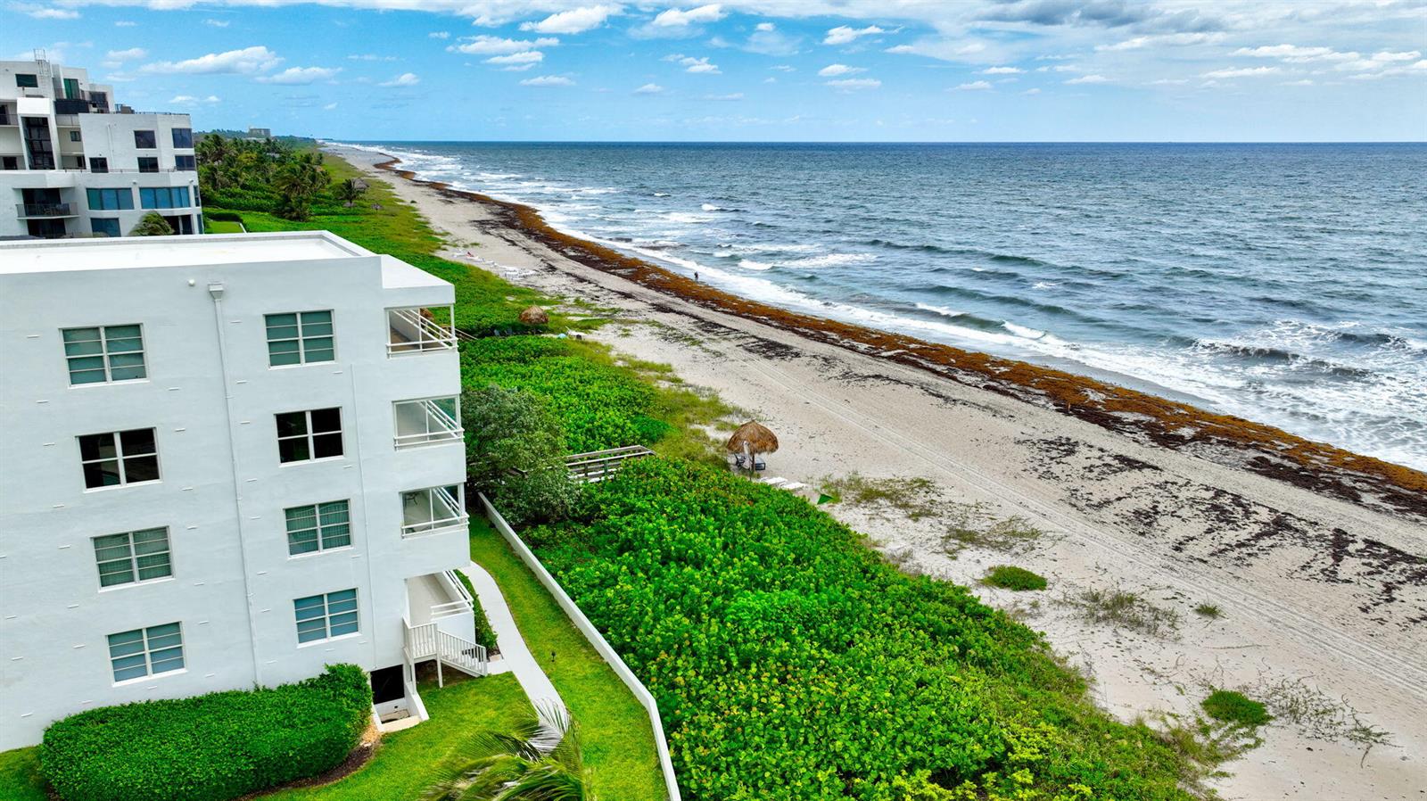 An aerial view shows a white multi-story building next to a sandy beach and ocean — 2701 S Ocean Boulevard # 21, Highland Beach FL 33487, HIGHLAND BEACH, FL