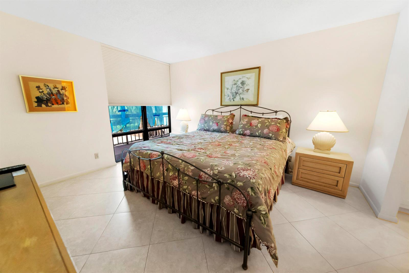 A bedroom features a floral-patterned bed, two nightstands with lamps, and tile flooring — 2687 N Ocean Boulevard # 303, Boca Raton FL 33431, BOCA RATON, FL