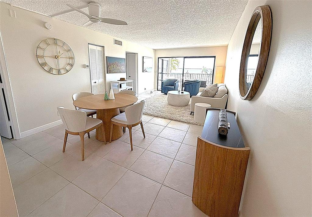 A dining and living area features tile floors, a round table, and a balcony view — 6322 PALMA DEL MAR BOULEVARD S UNIT 213, ST PETERSBURG, FL