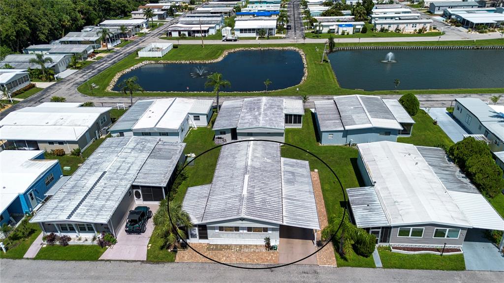 An aerial view shows a single-story mobile home with a metal roof and carport — 420 49TH STREET E UNIT 176, PALMETTO, FL
