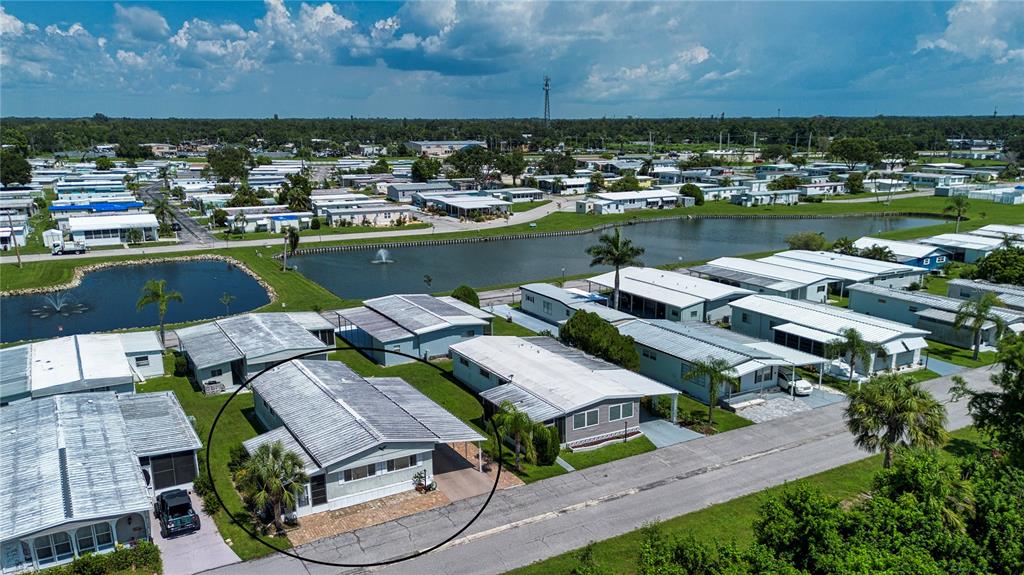 An aerial view shows a mobile home with a carport and driveway in a community — 420 49TH STREET E UNIT 176, PALMETTO, FL