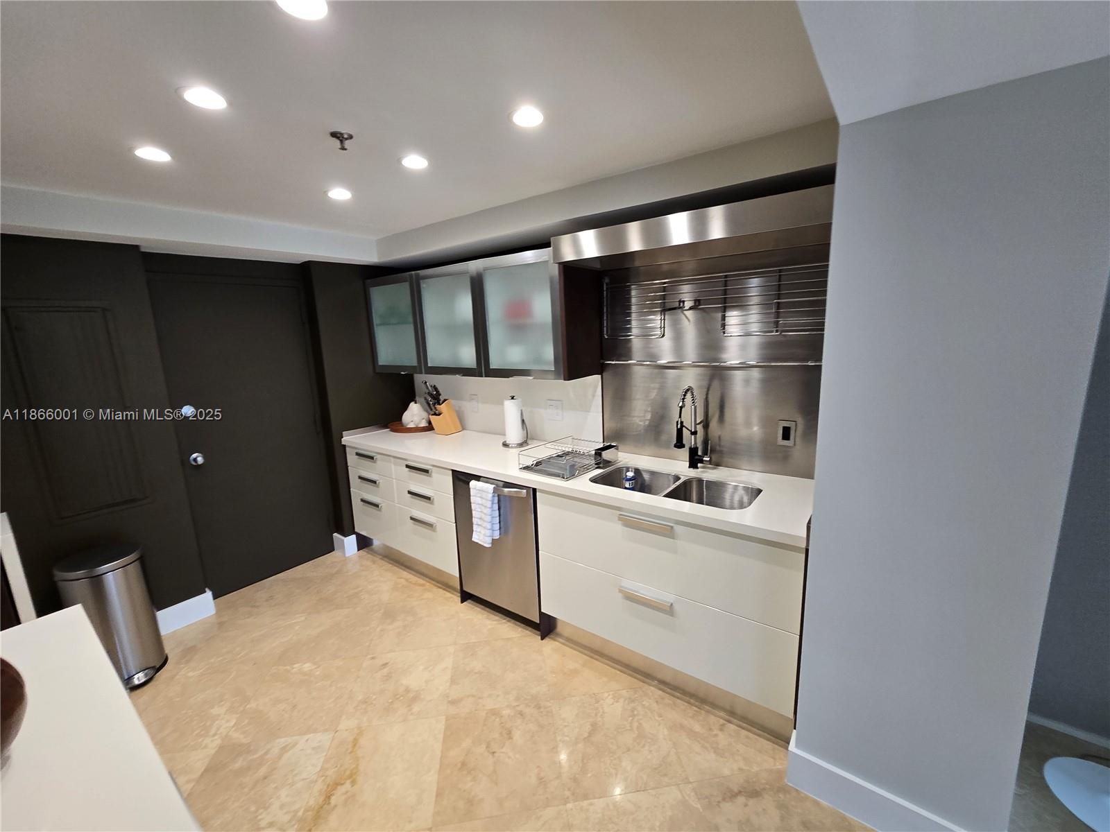A modern kitchen features white cabinets, stainless steel appliances, and a metallic backsplash — 11113 Biscayne Blvd # 854, Miami FL 33181, MIAMI, FL