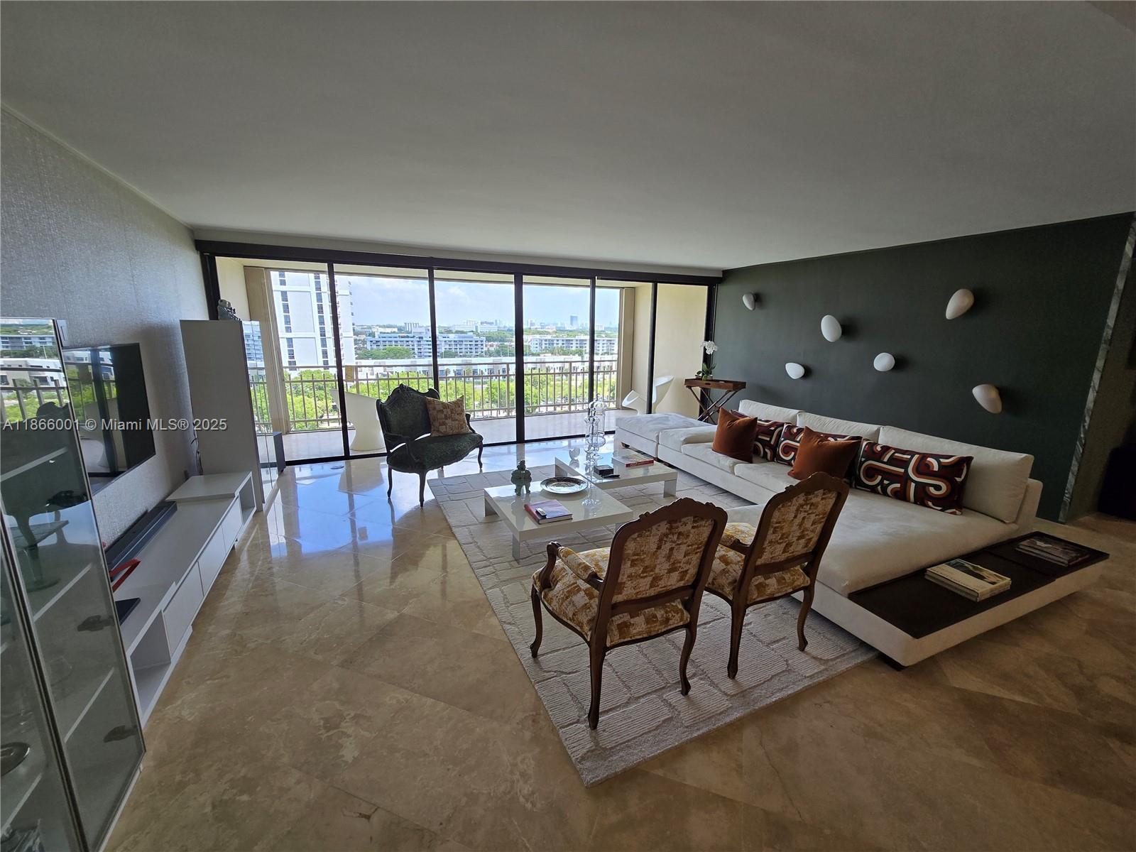 A spacious living room features marble floors, a large sectional sofa, and floor-to-ceiling windows — 11113 Biscayne Blvd # 854, Miami FL 33181, MIAMI, FL